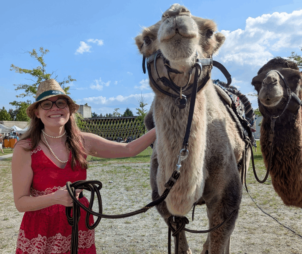 Female drummer with two camels smiling at camera and helping others find their beat